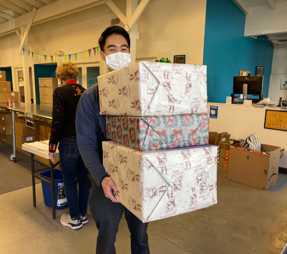 Young man standing with wrapped holiday presents.
