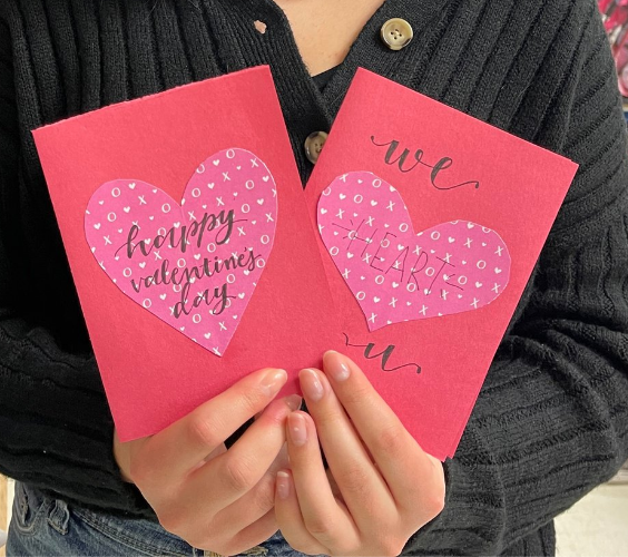 Young lady holding two decorated valentine's day cards