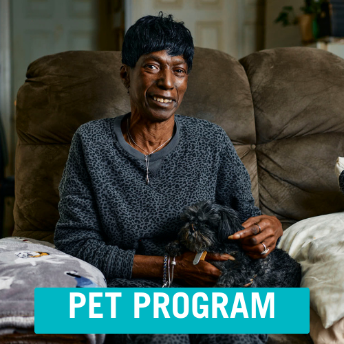 Client sitting in chair holding her dog