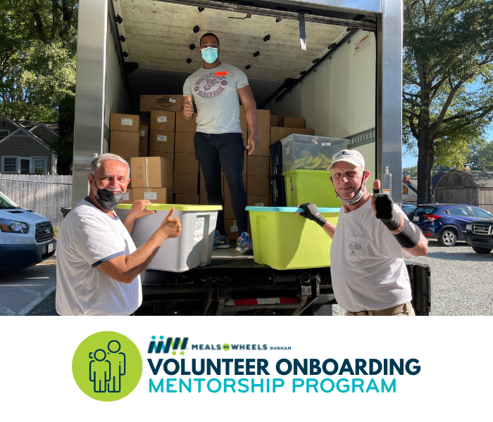 Three gentlemen raising a thumbs up as they unload bins of fruit from a truck.