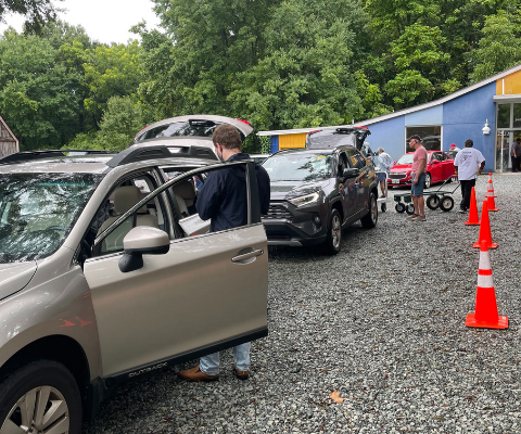 Volunteer delivery drivers lined up for their cars to be loaded with meals.