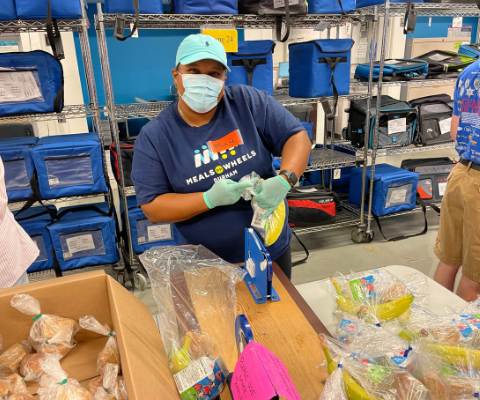 Volunteer packing plastic bag with a bananas.