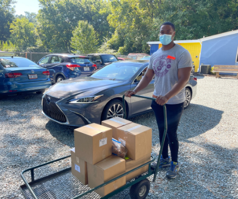 Young man standing with cart full of frozen meals.