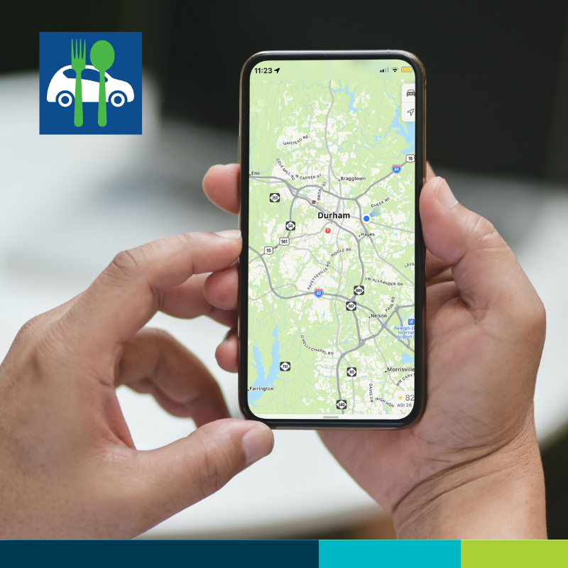 Man's hands holding phone with google map of the city of Durham.