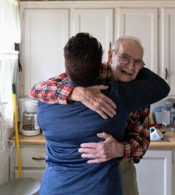 Annette hugging client in kitchen.