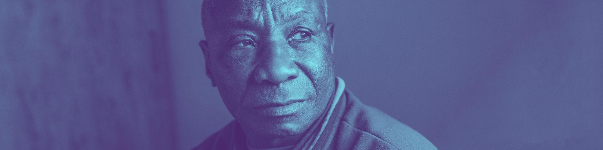 Older man staring off to the side in home.