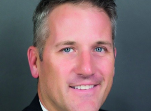 Kevin Dougherty's professional headshot smiling in front of a cool-toned background